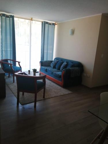sala de estar con sofá azul y mesa en Departamento de 3 habitaciones frente a la universidad de Talca, en Talca