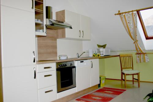 a kitchen with white cabinets and a stove top oven at Naturparkbauernhof Pöltl in Pöllau