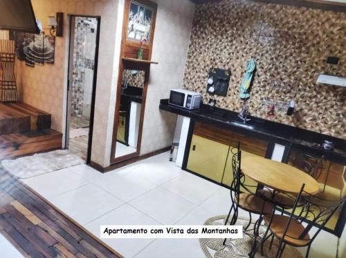 a room with a counter and a table and chairs at Sanctuary Pirenópolis Suítes e Flats in Pirenópolis