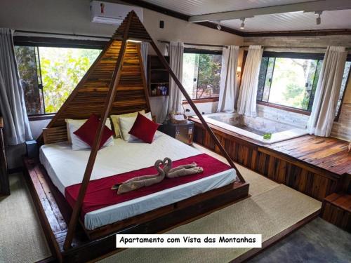 a bedroom with a hammock bed in a room with windows at Sanctuary Pirenópolis Suítes e Flats in Pirenópolis