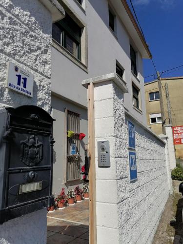 um edifício com uma caixa de correio preta ao lado dele em Albergue de Sonia em Finisterre