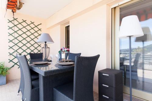une salle à manger avec une table et des chaises et une fenêtre dans l'établissement Studio vue mer panoramique sur la baie de Cannes, au Cannet