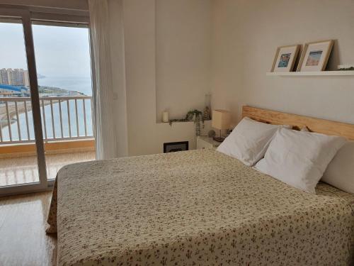 1 dormitorio con 1 cama y vistas a un balcón en La Manga - Puerto y Playa - 3 dormitorios en La Manga del Mar Menor