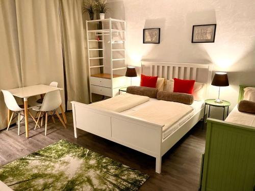 a bedroom with a white bed with red pillows at Munich Aparthotel in Munich