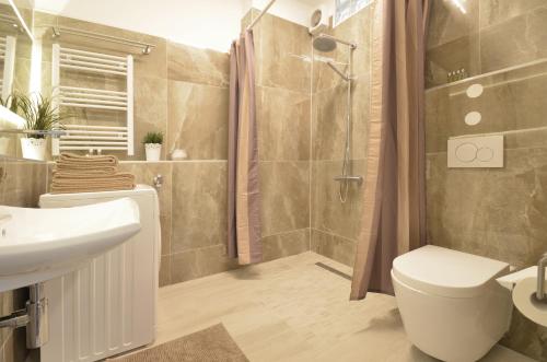 a bathroom with a shower and a toilet and a sink at Munich Aparthotel in Munich