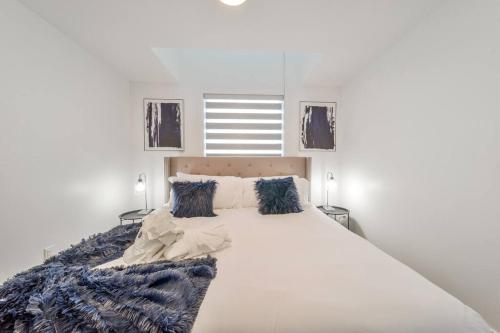 sypialnia z dużym białym łóżkiem z niebieskimi poduszkami w obiekcie Royal Blue Wild Oasis Corner PNHSE KingBed U/G Wi-fi w mieście Edmonton