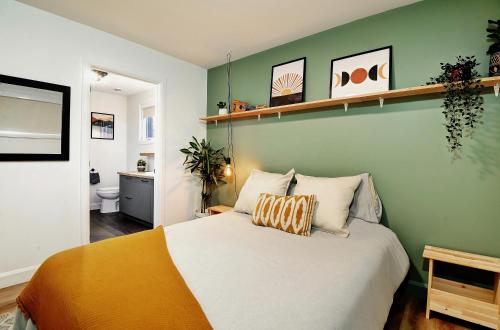 a bedroom with a bed and a green wall at 112 Chemin des Ruisselets in Stoneham