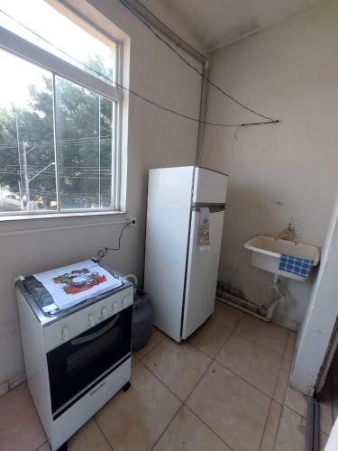a kitchen with a stove and a refrigerator at Apartamento aconchegante in Guaratinguetá