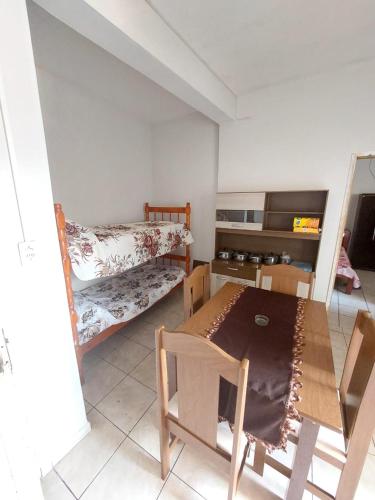 a room with two bunk beds and a table and chairs at Apartamento aconchegante in Guaratinguetá