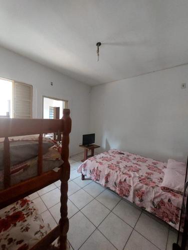 a bedroom with a bed and a television in it at Apartamento aconchegante in Guaratinguetá