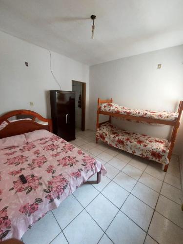 a bedroom with a bed and a dresser in it at Apartamento aconchegante in Guaratinguetá