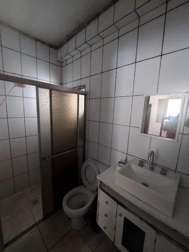 łazienka z toaletą i umywalką w obiekcie Apartamento aconchegante w mieście Guaratinguetá