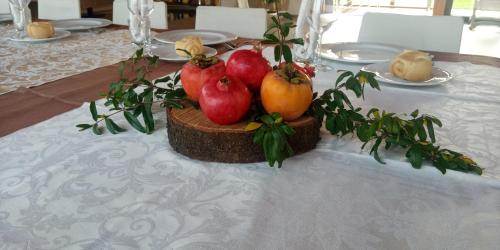 a table with a plate of pomegranates and vegetables on it at Agriturismo Le Valli in Liedolo