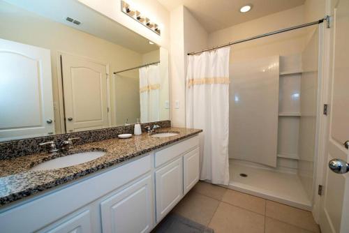 ein Bad mit 2 Waschbecken und einer Dusche in der Unterkunft Cozy Solterra 5Bed45Bath-Disney-No Resort Fee in Davenport