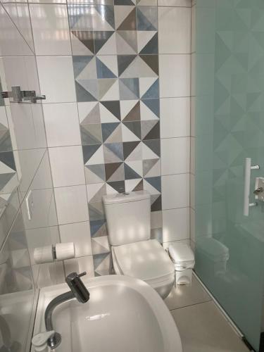 a small bathroom with a toilet and a sink at Pousada Internacional EAS 10min Aeroporto in Guarulhos