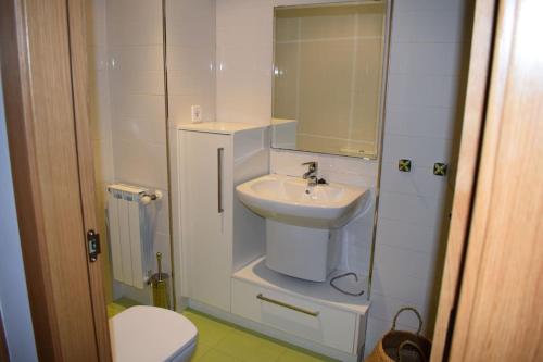 a small bathroom with a sink and a toilet at Apartamento centro Villagarcía. in Vilagarcia de Arousa