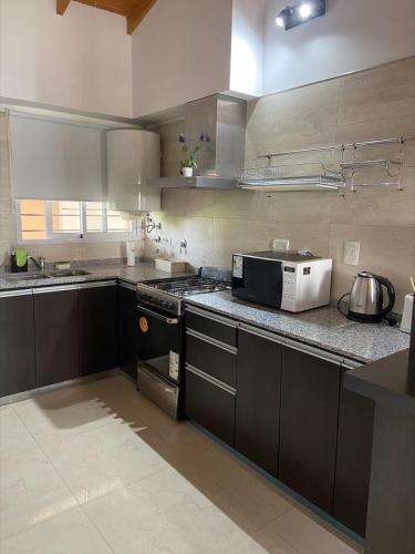 a kitchen with a stove and a microwave at Depto en Monte Grande a 15 minutos del Aeropuerto 2 Zona Residencial in Monte Grande