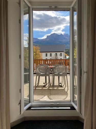 d'un balcon offrant une vue sur une table et des chaises. dans l'établissement Le Gaudissart 1, à Barcelonnette