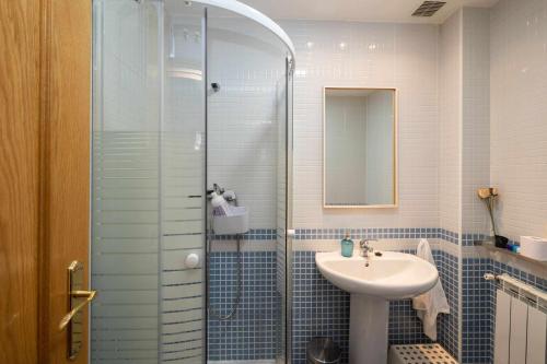 een badkamer met een glazen douche en een wastafel bij Casa benito en el corazón del casco histórico garaje incluido in Zamora