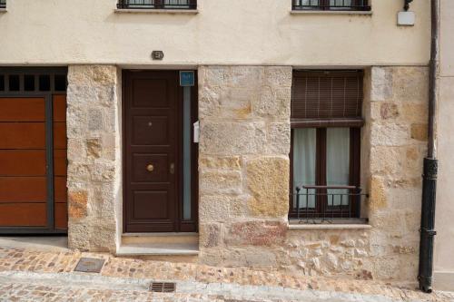 un edificio con una puerta marrón y dos ventanas en Casa benito en el corazón del casco histórico garaje incluido, en Zamora