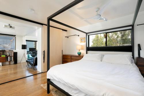 ロサンゼルスにあるArtSpace Venice Beach Rooftop House at Best Locationのベッドルーム(大きな白いベッド1台、大きな窓付)