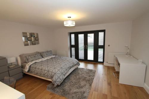 a bedroom with a bed and a desk in it at Lovely One Bed Apartment-Near All Transport-Village-FreeParking in London