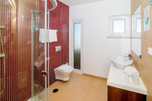 a bathroom with a shower and a toilet and a sink at Pine Tree Apartments - Praia da Coelha - Albufeira in Albufeira