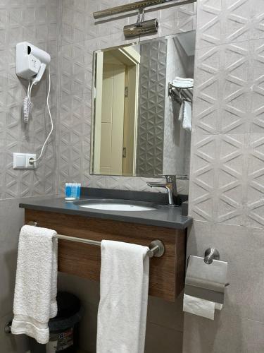 a bathroom with a sink and a mirror and towels at The Fresh Wave hotel in Batumi