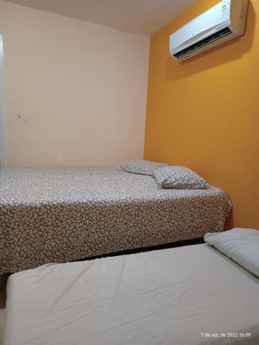 2 camas en una habitación con TV en la pared en Vista Maravilhosa da Praia Grande, en Arraial do Cabo