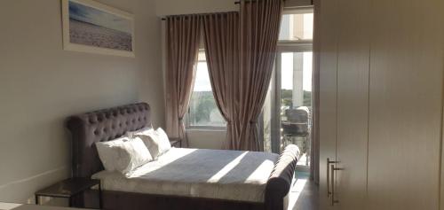 a bedroom with a bed in front of a window at Beachfront 3-bedroom with Robben Island views in Cape Town