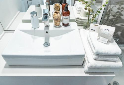 um lavatório branco com garrafas e toalhas num balcão em LM111A- Le mirage Estepona by Roomservices em Estepona