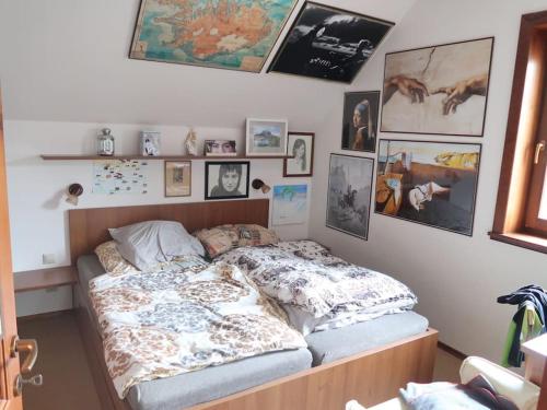 a bedroom with a bed with pictures on the wall at Byt 4+kk v klidné části obce Bedřichov in Bedřichov