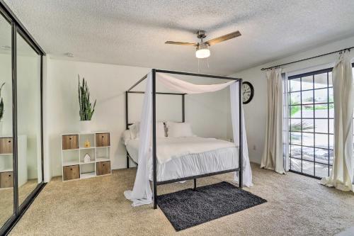 a bedroom with a canopy bed and a window at Bright Indio Home with Pool about 2 Mi to Coachella in Indio