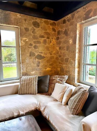 um sofá branco num quarto com duas janelas em Alemarni Parnassos em Polydrosos