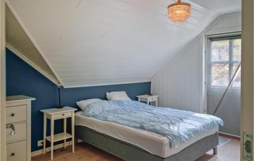 a bedroom with a bed with blue walls and a chandelier at 4 Bedroom Nice Home In Farsund in Farsund
