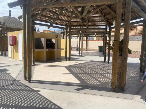 a pavilion with wooden posts and a building at Depto frente al mar in Antofagasta