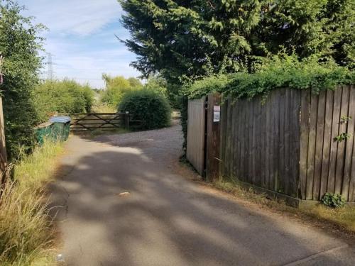 a dirt road next to a wooden fence at The Lodge at Pickford House NEC and B'Ham Airport, Coventry in Coventry
