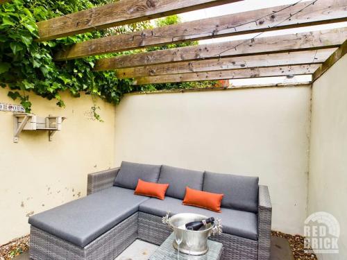 a bench with two orange pillows on a patio at The Lodge at Pickford House NEC and B'Ham Airport, Coventry in Coventry