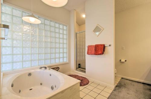 a large bathroom with a tub and a window at Bright Waterfront Condo with Resort Amenities! in Lake Ozark