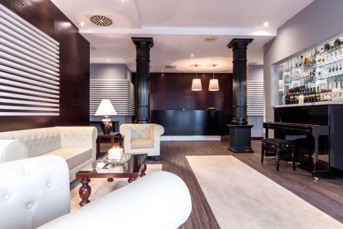 a living room with a white couch and a piano at Hotel Am Blauen Wunder in Dresden