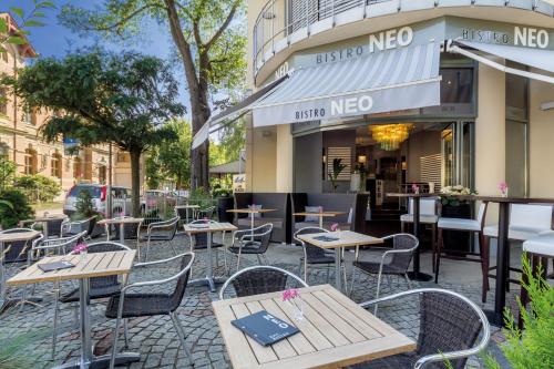 una fila di tavoli e sedie di fronte a un ristorante di Hotel Am Blauen Wunder a Dresda