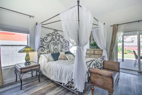 1 dormitorio con cama con dosel, mesa y silla en Glendale Oasis with Saltwater Pool and Hot Tub!, en Phoenix