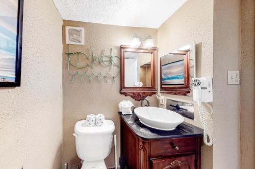 y baño con lavabo, aseo y espejo. en Victorian Condos Tranquility at the Victorian 3224 en Galveston