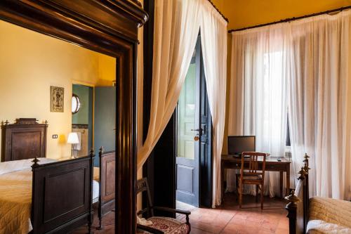 a bedroom with a bed and a desk and a window at Domus Laeta in Giungano