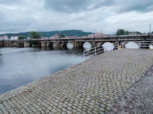 uma ponte sobre um rio com uma ponte sobre a água em Virxen do Carmen 7 alojamiento em Puentecesures