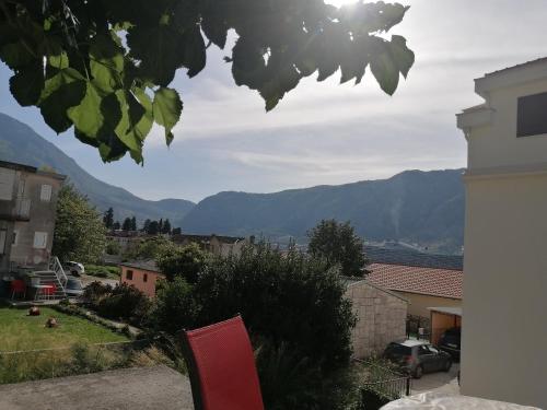 a red chair in a yard with mountains in the background at Apartments Željka-Dobrota in Kotor