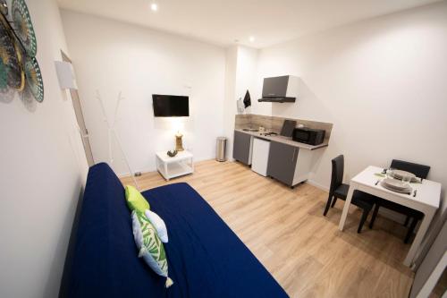a living room with a blue bed and a kitchen at !!USHUIÄ!! Superbe studio HOME STAGING en plein CENTRE-VILLE. in Saint-Quentin