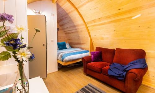 a living room with a chair and a bed at Willow Tree Barn Pod in Kendal