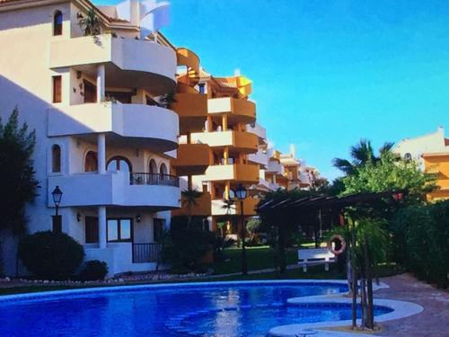 ein Gebäude mit einem Pool vor einem Gebäude in der Unterkunft Panorama Park, Punta Prima, 5 star Luxury 2 bedroom Apartment like no other in Alicante