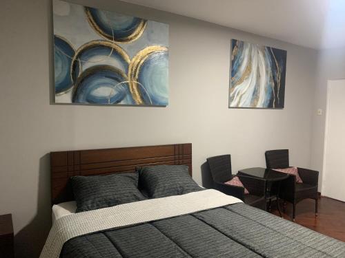 um quarto com uma cama e duas pinturas na parede em Iguana Haus Lima em Lima